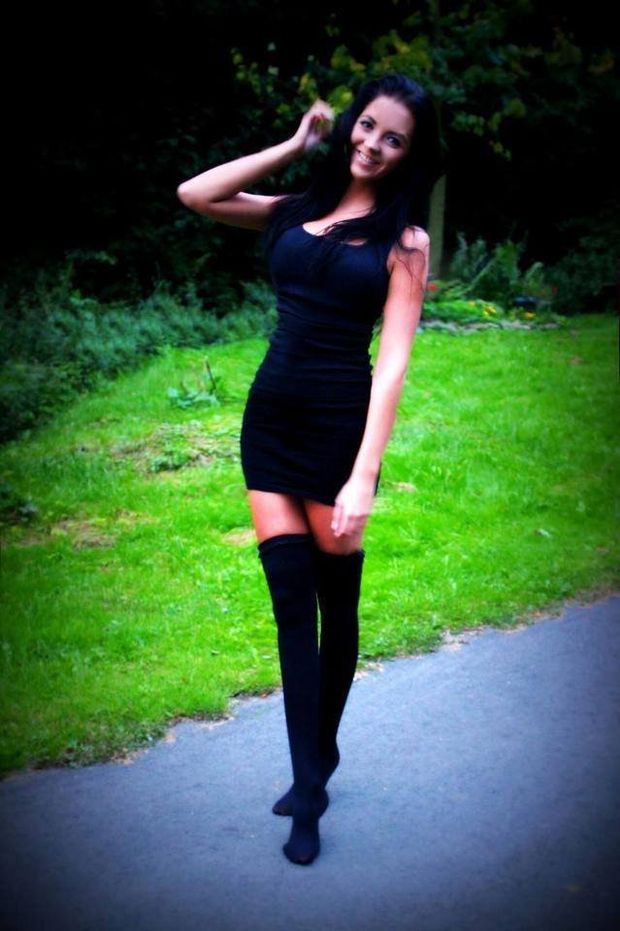 Adorable brunette posing outdoors in black mini dress