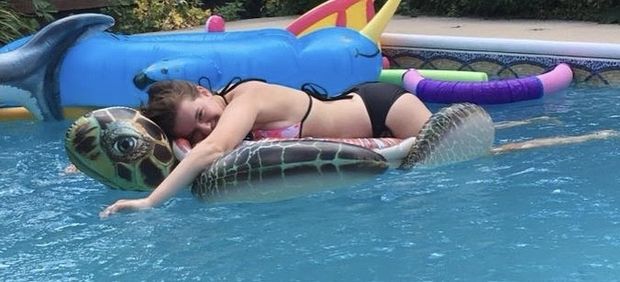 Teen laying on a pool float