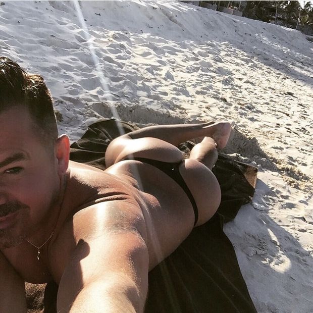 Sexy man tanning in thong