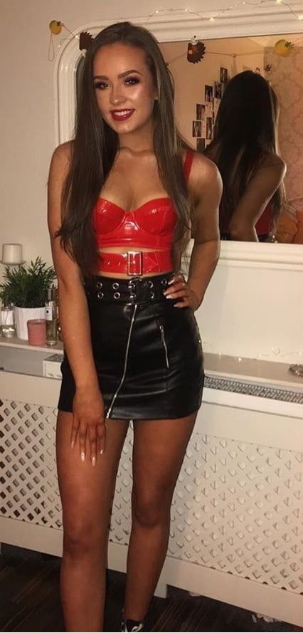 Tanned babe in black short leathe skirt and leather red top