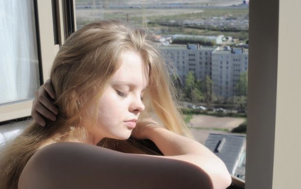 Kisa resting on her arm in a window